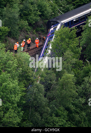 Gli ingegneri ispezionano il treno deragliato vicino alla centrale elettrica Falls of Cruachan, da Loch awe ad Argyll. Foto Stock