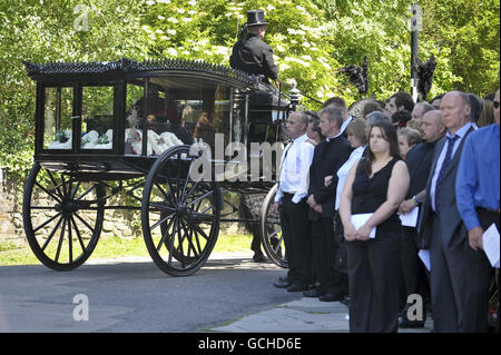 La carrozza a cavallo che porta la bara dell'ex batterista Stereophonics Stuart Cable, arriva alla chiesa di St Elvans ad Aberdare, Galles. Foto Stock