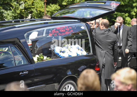 I Pallbearers collocano la bara nera, con motivi fulmini sulla parte anteriore, dell'ex batterista Stereophonics Stuart Cable, nel cuore mentre il corteo si prepara a partire alla chiesa di St Elvans ad Aberdare, Galles. Foto Stock