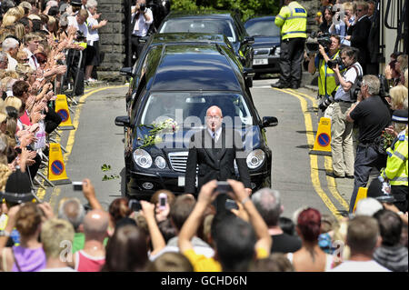 Le folle si riuniscono come il corteo funebre dell'ex batterista Stereophonics Stuart Cable, lascia la chiesa di St Elvans ad Aberdare, Galles. Foto Stock