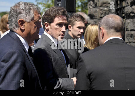 L'attore Rob Brydon (centro) arriva al funerale dell'ex batterista Stereophonics Stuart Cable, nella chiesa di St Elvans ad Aberdare, Galles. Foto Stock