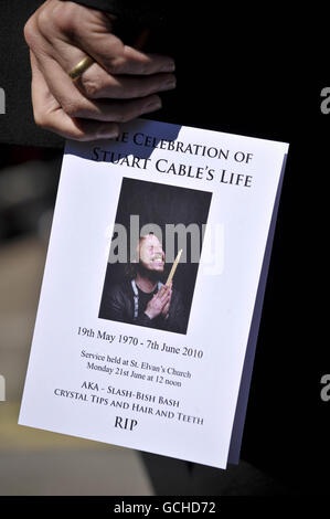 Un Mourner detiene l'ordine di servizio ai funerali dell'ex batterista Stereophonics Stuart Cable, presso la chiesa di St Elvans ad Aberdare, Galles. Foto Stock