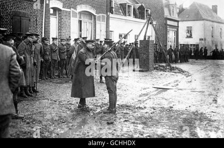 RE GIORGIO V DECORÒ UN CAVALLERISTA BRITANNICO DURANTE UNA DELLE SUE OTTO VISITE ALLE TRUPPE IN FRANCIA DURANTE LA PRIMA GUERRA MONDIALE. SIR DOUGLAS HAIG GUARDA SU, APPOGGIATO SU UN BASTONE DA PASSEGGIO. 1914. Foto Stock