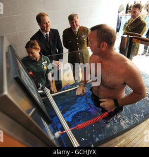 Il principe William (seconda a sinistra) condivide una battuta con il Royal Marine Dave Corcoran (fronte) durante un tour del complesso di riabilitazione Help for Heroes, presso il Defense Medical Rehabilitation Center (DMRC), a Headley Court, in Surrey. Foto Stock