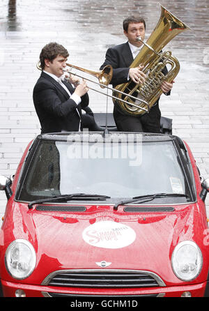 La Royal Scottish National Orchestra (RSNO) il principale giocatore di trombone Davur Juul Magnussen e il Principal Tube John Whitener si esibiscono in un Mini convertibile su Buchanan Street a Glasgow per promuovere i concerti estivi RSNO. Foto Stock