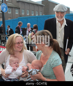 Sir Sean Connery (a destra) guarda due donne mentre ritorna alla strada dove è nato a Fountainbridge, Edimburgo, 80 anni fa per incontrare le organizzazioni coinvolte nella sua rigenerazione. Foto Stock