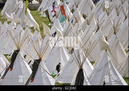 Un uomo cammina attraverso il campo di teepee il giorno in cui la musica inizia al Glastonbury Festival 2010, il 40° anniversario dell'evento, presso Worthy Farm, Pilton, Somerset. Foto Stock