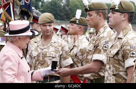 La Regina Elisabetta II della Gran Bretagna presenta Campaign Medals ai soldati del 1° Battaglione reale gallese, durante il servizio della testa di batteria del Ringraziamento per segnare il loro ritorno dalle operazioni in Afghanistan, all'Ippodromo di Chester, Chester. Foto Stock