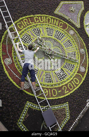 Un giardiniere mette il tocco finale al Floral Clock in Princes Street Gardens a Edimburgo. Foto Stock