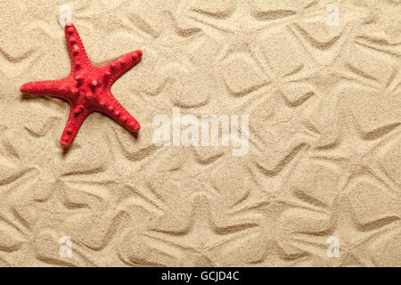 Starfish patterns con la rossa stella di mare sulla spiaggia di sabbia di background Foto Stock