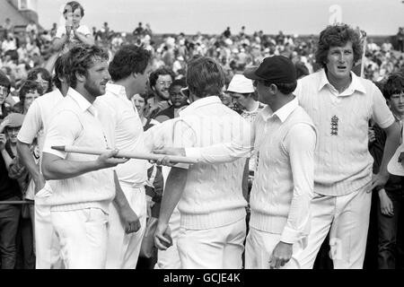 Geoff Boycott consegna a Ian Botham un moncone mentre le celebrazioni iniziano dopo la vittoria della serie inglese sull'Australia. Bob Willis (r) in Inghilterra taglia una figura stanca. Foto Stock