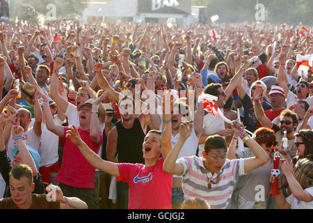 Gli appassionati di calcio celebrano il primo gol dell'Inghilterra contro gli Stati Uniti mentre guardano la Coppa del mondo su un grande schermo all'Isle of Wight Music Festival. Foto Stock