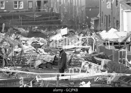 Un poliziotto si trova in piedi guardia sulle case danneggiate nel Pan am Boeing 747 Lockerbie crash, che ha ucciso tutti i 258 a bordo e 17 persone a terra. Foto Stock