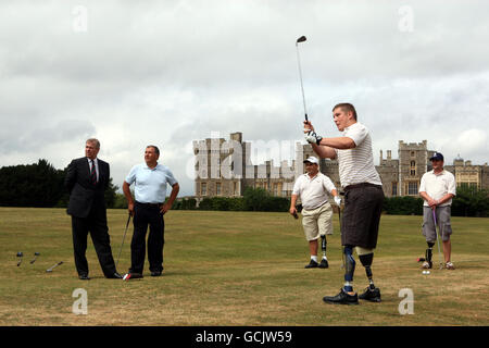 Il Duca di York (a sinistra) guarda come Sapper Greg Stevenson, che ha perso le gambe servendo in Afghanistan, prende un colpo durante il lancio della beneficenza on Course per i militari feriti e le donne al Royal Household Golf Club nei terreni del Castello di Windsor nel Berkshire. Foto Stock