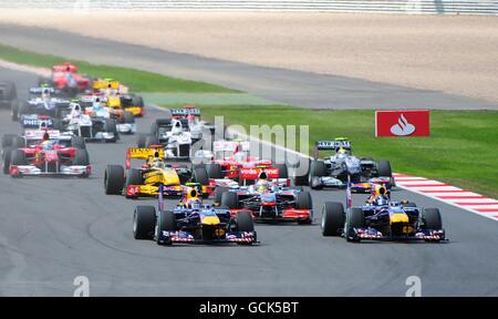 Mark Webber (a sinistra) della Red Bull Racing conduce il compagno di squadra Sebastian Vettel alla prima curva durante il Gran Premio di Gran Bretagna di Santander al circuito di Silverstone, Northampton. Foto Stock