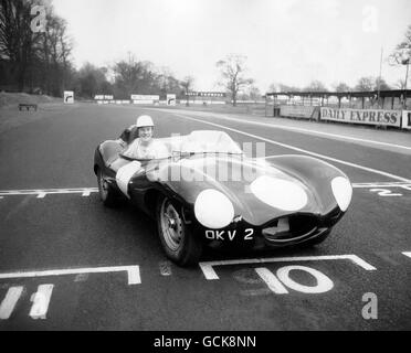 L'ex campione del mondo del Ciclismo Reg Harris al volante di Una potente Jaguar D-Type che è dovuta alla gara Al British Empire Trophy Race a Oulton Park questo fine settimana Foto Stock