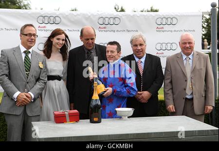 Jockey Kieron Fallon (centro) raccoglie il suo premio dopo aver vinto l'Audi King George Stakes su Borderlescott, con l'allenatore Robin Bastiman (centro a sinistra) e Sophie Ellis-Bextor (2° a sinistra) durante il terzo giorno del glorioso Festival del Goodwood presso l'ippodromo di Goodwood, Chichester. Foto Stock