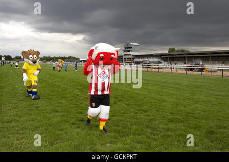 La volpe Filbert di Leicester City (a sinistra) e la Poacher di Lincoln City Imp fare lì modo fino l'ippodromo Foto Stock