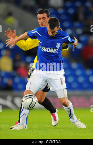 Paul Quinn di Cardiff City (fronte) e James Ellison di Burton Albion combatti per la palla Foto Stock