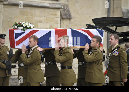 Pallbearers dai Fucili spalla la bandiera dell'Unione ha drappeggiato la bara del maggiore Josh Bowman mentre è condotto nella cattedrale di Salisbury dove un servizio funerale è tenuto in suo onore. Foto Stock