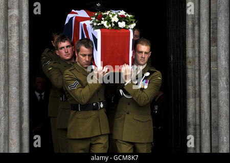 Pallbearers dai Rifles spalla la bandiera dell'Unione ha drappeggiato la bara del maggiore Josh Bowman mentre è effettuato dell'entrata occidentale dalla cattedrale di Salisbury dove un servizio funerario è stato tenuto in suo onore. Foto Stock