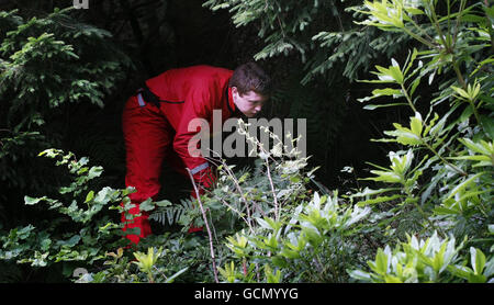 Un membro di un team di ricerca cerca il corpo di Suzanne Pilley vicino a Loch Long in Scozia. Foto Stock