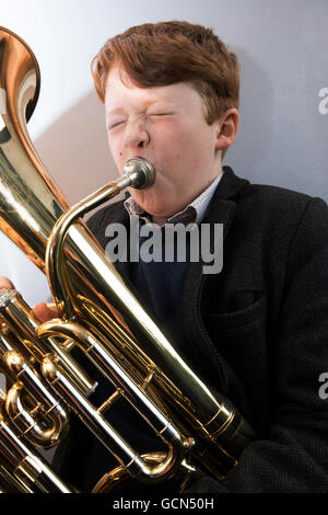 11-anno vecchio ragazzo giocando un baritono avvisatore acustico Foto Stock