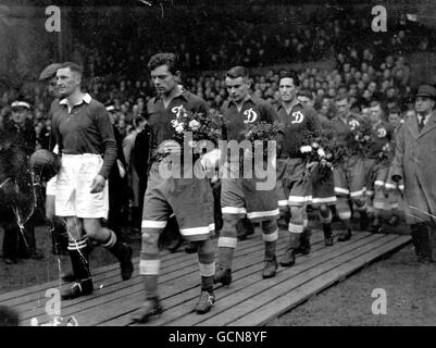 Mosca Dynamo F.C. ha girato la loro migliore squadra di giorno contro Chelsea a Stamford Bridge per la prima partita del loro tour in inglese. Una folla enorme, tra cui molti russi, ha accolto i visitatori. Persone di diversi paesi avevano portato biglietti per onorare gli uomini che avevano contribuito a sconfiggere la Germania nelle fabbriche dell'Esercito Rosso. La quota di dinamos del cancello pesante sarà donata a enti di beneficenza dal F.A. come diretto dai russi. Il fondo di Stalingrad ha un alto posto. L'immagine mostra Harris, capitano del Chelsea, e Semichastny, capitano della dinamo, che conduce le loro squadre nel campo. I russi portano bouquet di Foto Stock