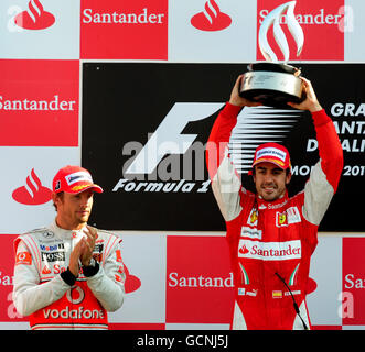 Fernando Alonso della Ferrari (destra) celebra la sua vittoria sul podio con la seconda McLaren Mercedes Jenson Button della Gran Bretagna durante il Gran Premio d'Italia sul circuito di Monza. Foto Stock