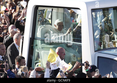 Papa Benedetto XVI trasuda dal Popemobile alle folle del Bellahouton Park di Glasgow, prima di una messa all'aperto durante il primo giorno di una visita di quattro giorni nel Regno Unito. Foto Stock