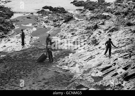 L'olio della petroliera Torrey Canyon brilla sulle rocce mentre le truppe spruzzano detersivo alla piccola spiaggia e alla zona di balneazione di Dollar Cove nel villaggio della Cornovaglia di Gunwalloe. Foto Stock