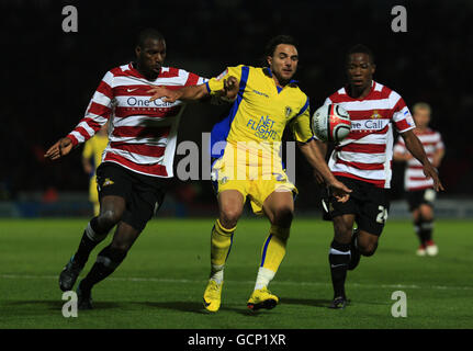 Il Leeds United's Davide somma (centro) combatta con i difensori di Doncaster Rovers Shelton Martis e Mustapha Dumbuya (a destra) durante la partita del campionato della Npower Football League allo stadio Keepmoat di Doncaster. Foto Stock