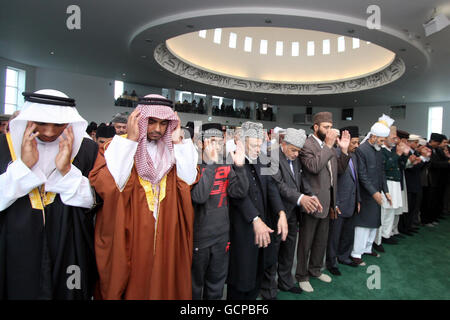 Musulmani Ahmadi alla Moschea di Baitul Futuh a Morden, Londra, la più grande moschea dell'Europa occidentale, dopo aver celebrato l'Eid con la preghiera, durante la quale oltre 10,000 fedeli hanno ricevuto un sermone dell'Eid dal capo mondiale della comunità musulmana Ahmadiyya, sua Santità, Hadhrat Miza Masroor Ahmad. Foto Stock