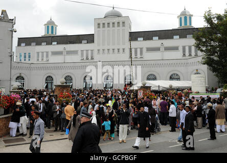 i musulmani Ahmadi partono dalla moschea di Bahitl Futuh a Morden, Londra, la più grande moschea dell'Europa occidentale, dopo aver festeggiato Eid con la preghiera, in cui oltre 10,000 fedeli hanno ricevuto un sermone Eid dal capo mondiale della comunità musulmana Ahmadiyya, sua Santità, Hadhrat Miza Masroor Ahmad. Il sermone è stato trasmesso in telelavoro in tutto il mondo e la comunità ha anche reso omaggio alle vittime delle 9/11 attrocità terrore in America, nel nono anniversario degli attacchi. Foto Stock