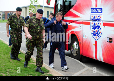 Inghilterra sotto 21 il direttore Stuart Pearce cammina oltre il loro autobus con due ufficiali dell'esercito durante un tour di 16 Air Assault Brigade e Colchester Garrison, Colchester. Foto Stock