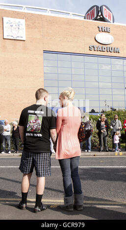 I tifosi indossano i top in memoria dell'ex star della Rugby League inglese Terry Newton durante la processione funeraria fuori dal DW Stadium, Wigan. Foto Stock