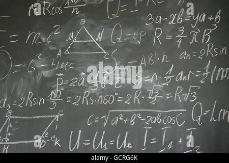Le formule matematiche sulla lavagna nera Foto Stock