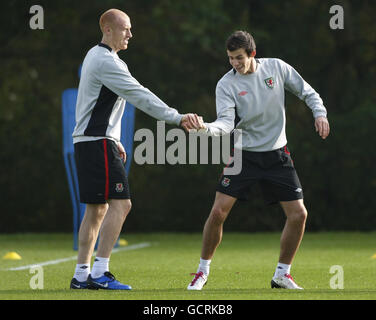 Il Wales Gareth Bale e James Collins (a sinistra) si aggrappano l'uno con l'altro durante la sessione di formazione al vale of Glamorgan Hotel, Cardiff, Galles. Foto Stock