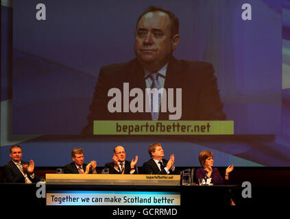 I membri del gabinetto SNP (da sinistra a destra) Richard Lochhead MSP, Kenny MacAskill MSP, John Swinney MSP, Angus Robertson MSP e il vice leader SNP Nicola Sturgeon guardano il leader SNP Alex Salmond durante il suo discorso presso la sala concerti di Perth l'ultimo giorno della conferenza annuale del suo partito che si terrà a Perth. Foto Stock