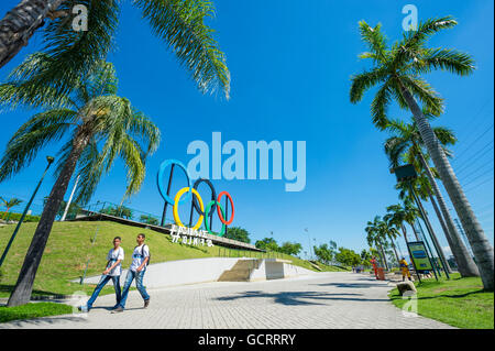 RIO DE JANEIRO - MARZO 18, 2016: i giovani brasiliani a piedi nella parte anteriore di anelli olimpici installato per il 2016 Giochi estivi in un parco. Foto Stock