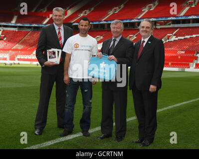 David Gill (a sinistra), Ryan Giggs e Sir Alex Ferguson si mettono in posa con il direttore generale dell'UNICEF David Bull (a destra) dopo la conferenza stampa dell'UNICEF di Manchester, a Old Trafford, Manchester. Foto Stock