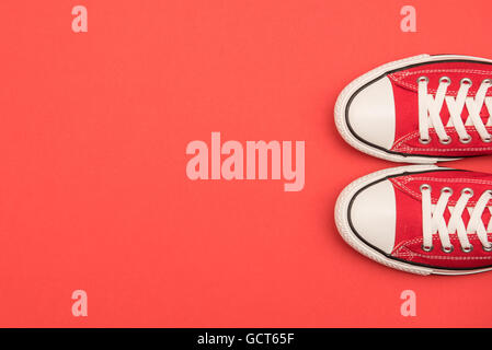 Sneakers rossa su uno sfondo rosso Foto Stock