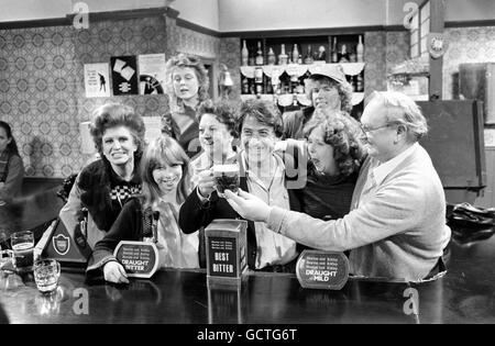 L'attore cinematografico americano Dustin Hoffman, centro, prova una pinta di birra nel 'Rovers Return'. Stava visitando il Manchester TV Studio dove la lunga serie britannica 'Coronation Street' è fatta. Pat Phoenix, è estrema sinistra, mentre Fred Feast serve la pinta come altri membri del cast guardare sopra. Foto Stock