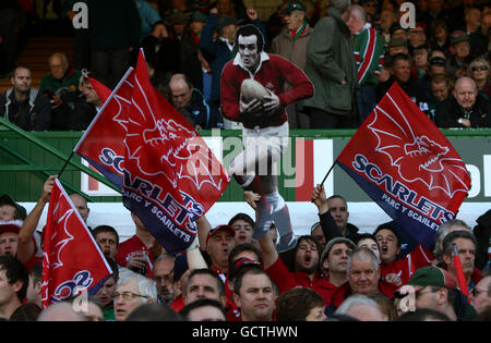 Llanelli Scarlets tifosi mostrare il loro sostegno negli stand come Presentano un taglio di cartone di Llanelli ex e Galles Fly mezzo Phil Bennett Foto Stock