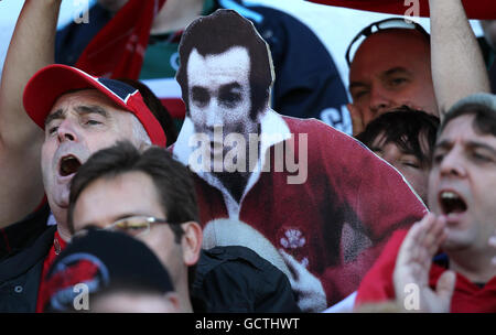 Llanelli Scarlets tifosi mostrare il loro sostegno negli stand come Presentano un taglio di cartone di Llanelli ex e Galles Fly mezzo Phil Bennett Foto Stock