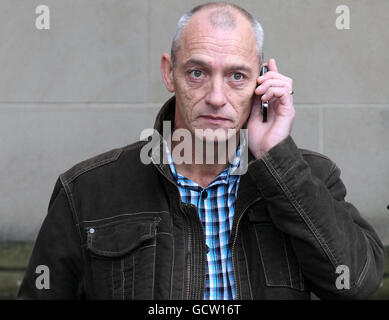 Osserva George McNeilage sul suo telefono cellulare fuori dalla High Court di Glasgow, dove sta dando prove al processo della pergiuria di Tommy e Gail Sheridan. Foto Stock