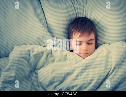 A sette anni di età bambino nel letto Foto Stock