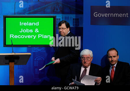 Taoiseach Brian Cowen (a sinistra) si prepara ad annunciare il piano di ripresa nazionale in qualità di Ministro degli Affari Esteri Michael Martin (a destra) e Ministro per il Commercio delle imprese e l'innovazione Batt o'Keefe Look on, presso il Centro stampa governativo di Dublino. Foto Stock