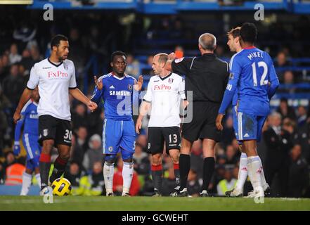 Calcio - Barclays Premier League - Chelsea v Fulham - Stamford Bridge. L'arbitro Martin Atkinson (seconda a destra) mostra Michael Essien (seconda a sinistra) di Chelsea la carta rossa Foto Stock