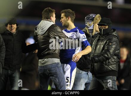 Calcio - Carling Cup - Quarter Final - Birmingham City / Aston Villa - St Andrews' Stadium. Roger Johnson di Birmingham City è scossato dai fan dopo aver invaso il campo dopo il fischio finale Foto Stock